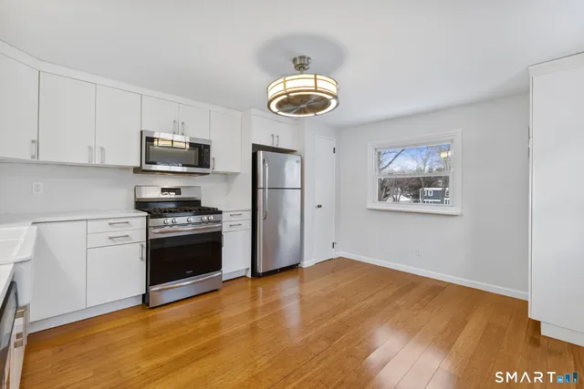 a view of a kitchen with stainless steel appliances granite countertop a stove and a refrigerator