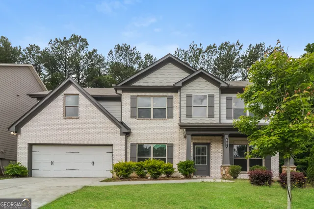 a front view of a house with a garden and plants