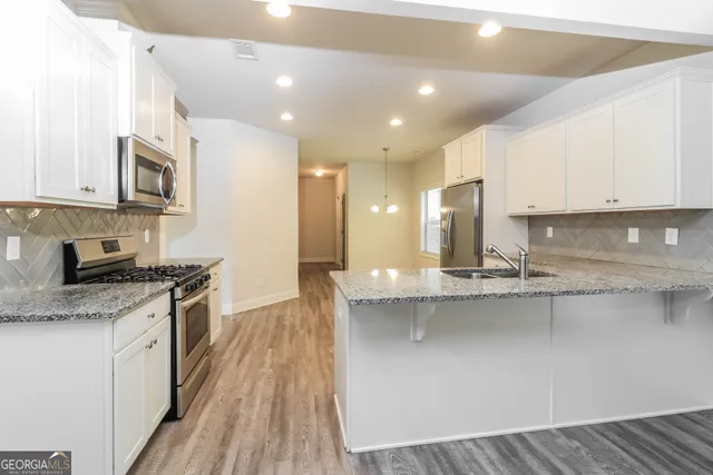 a kitchen with stainless steel appliances granite countertop a stove a sink and a microwave