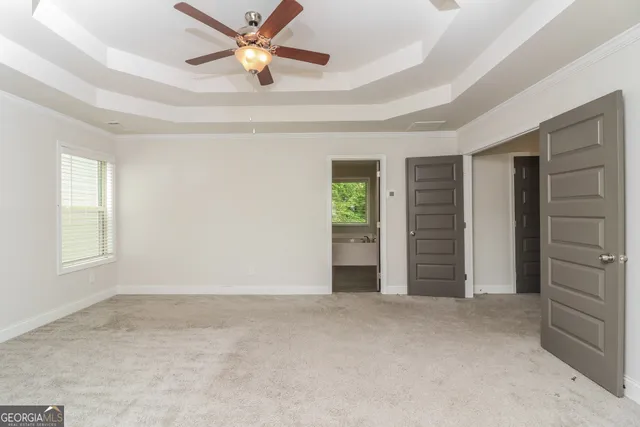 an empty room with closet and a ceiling fan
