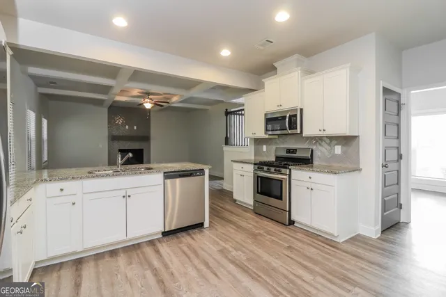 a kitchen with granite countertop a sink and steel appliances