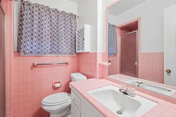 a bathroom with a sink a toilet and a mirror