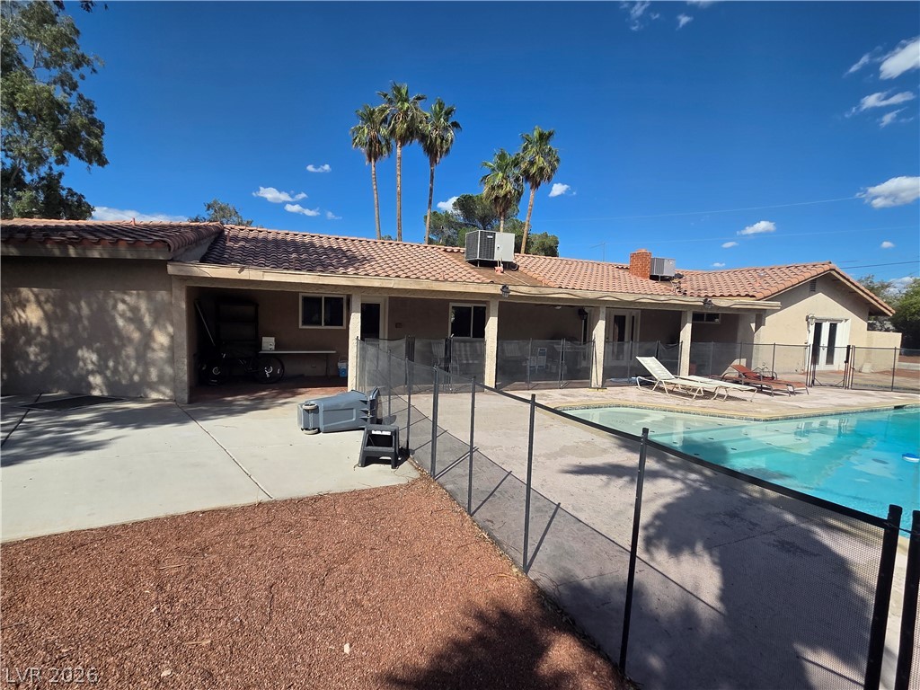 3381 Westwind Road Las Vegas, NV 89146 - Photo 9 of 52 A spacious concrete patio surrounds a fenced in-ground pool, offering an ideal setting for outdoor recreation.