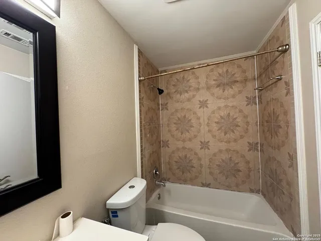 a bath room with a toilet and a bath tub