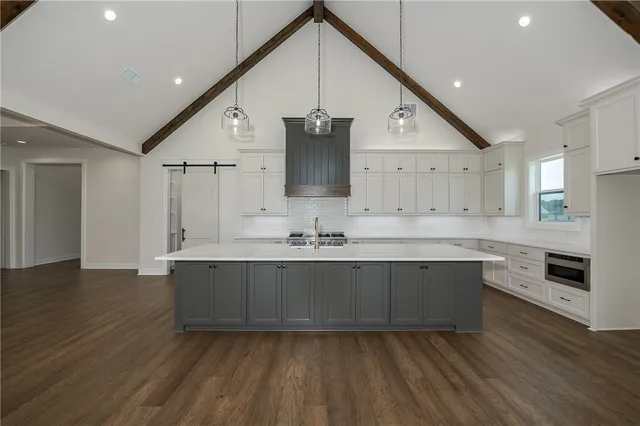 a large kitchen with stainless steel appliances granite countertop a sink and a wooden floors