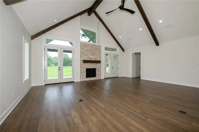 a view of empty room with wooden floor and fireplace