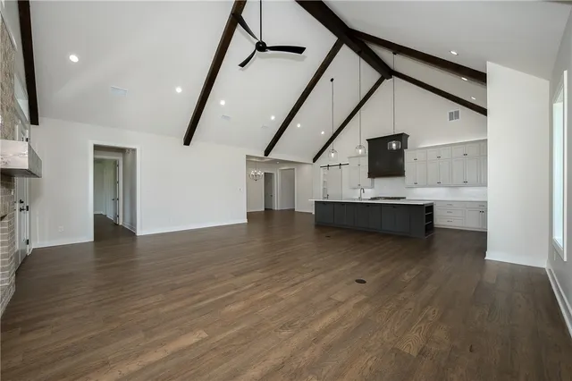 a view of kitchen and empty room with wooden floor