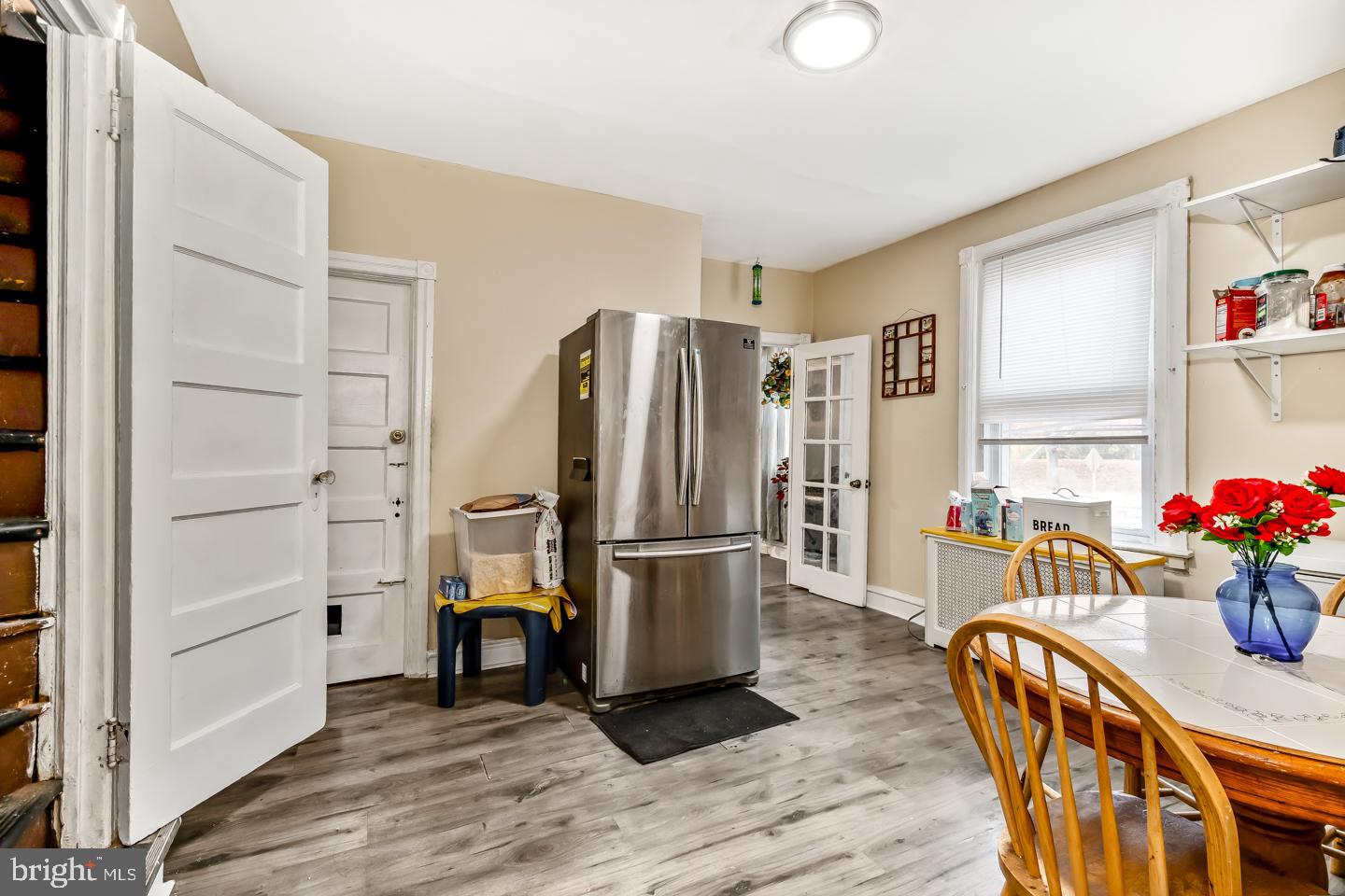 6243 Carpenter Street Philadelphia, PA 19143 - Photo 16 of 55 a kitchen with stainless steel appliances granite countertop a refrigerator a microwave a stove and white cabinets with wooden floor