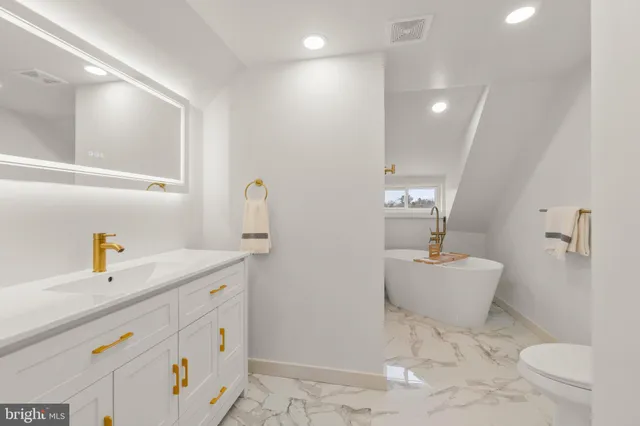 a bathroom with a sink a toilet and a mirror