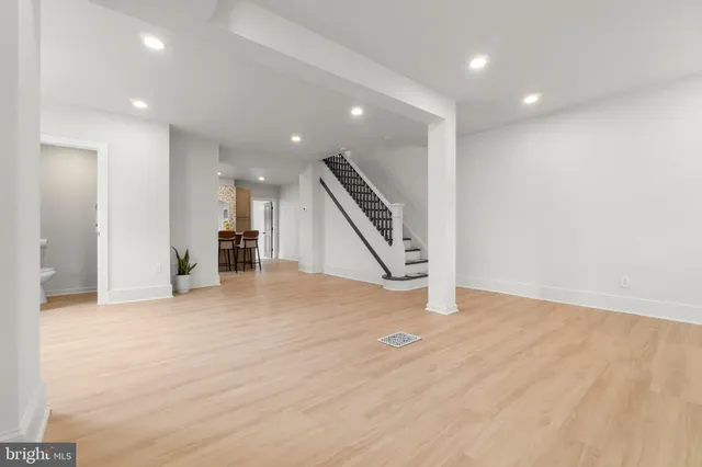 an empty room with wooden floor and entryway