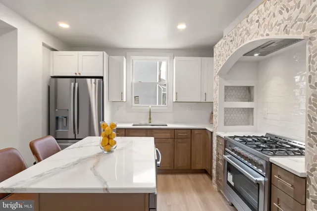 a kitchen with stainless steel appliances granite countertop a sink stove and refrigerator