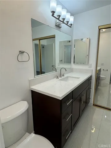 a bathroom with a sink a toilet and mirror
