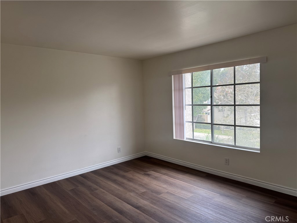 6 Columbia, Unit 2 Irvine, CA 92612 - Photo 18 of 25 an empty room with wooden floor and windows