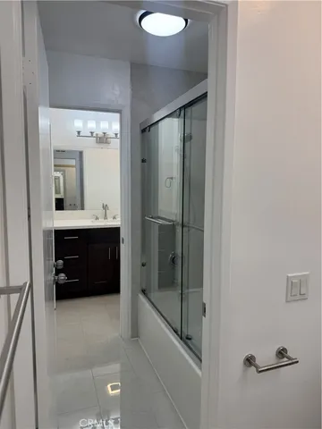 a bathroom with a tub a sink and mirrors