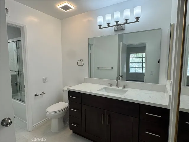 a bathroom with a sink vanity toilet and shower