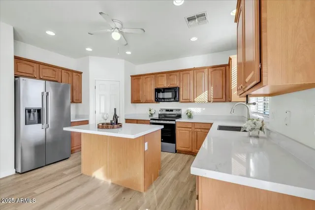 a kitchen with stainless steel appliances granite countertop a sink stove and refrigerator