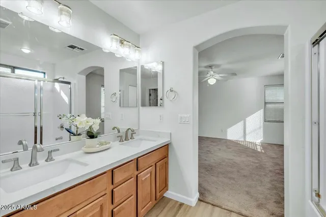 a bathroom with a double vanity sink mirror and shower