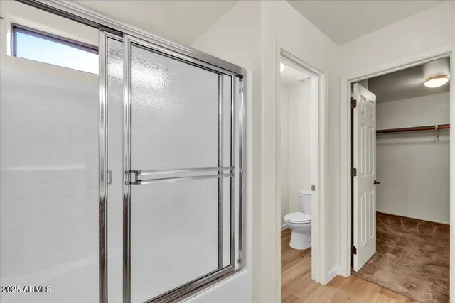 a bathroom with a glass shower door and a toilet