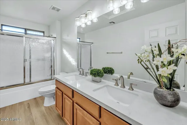 a bathroom with a granite countertop sink a toilet and a mirror