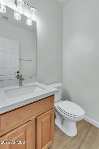 a bathroom with a granite countertop toilet sink and mirror