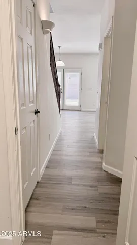 a view of a hallway with wooden floor and staircase