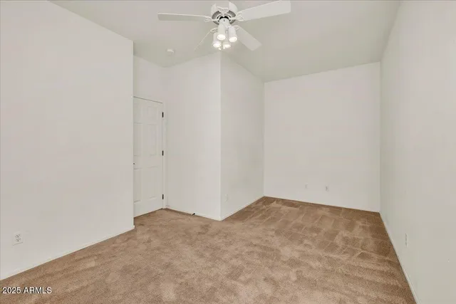 an empty room with a ceiling fan and a window