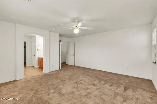 an empty room with a ceiling fan and a window