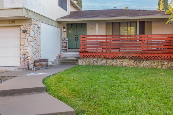 a view of a house with a small yard and wooden fence