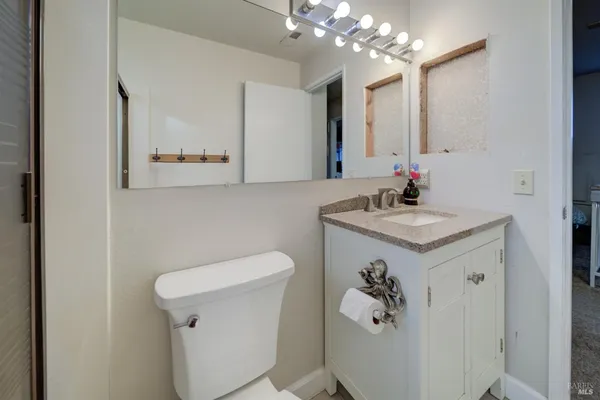 a bathroom with a granite countertop sink a toilet and shower