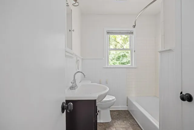 a bathroom with a sink a toilet and shower
