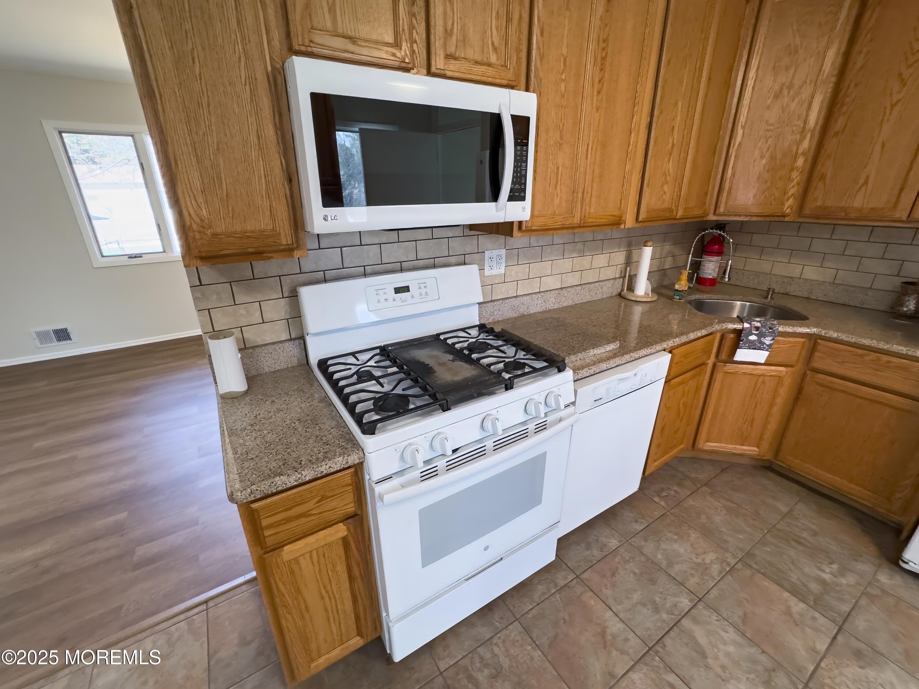 30 Bryant Drive Jackson, NJ 08527 - Photo 10 of 58 a kitchen with granite countertop a stove sink and cabinets