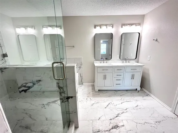 a bathroom with a double vanity sink mirror and shower