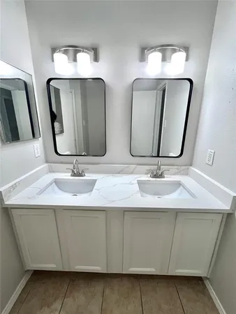 a bathroom with double vanity sinks and a mirror