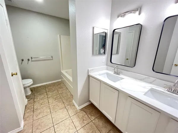 a bathroom with double vanity sink and mirror