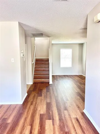 a view of a room with wooden floor and white walls