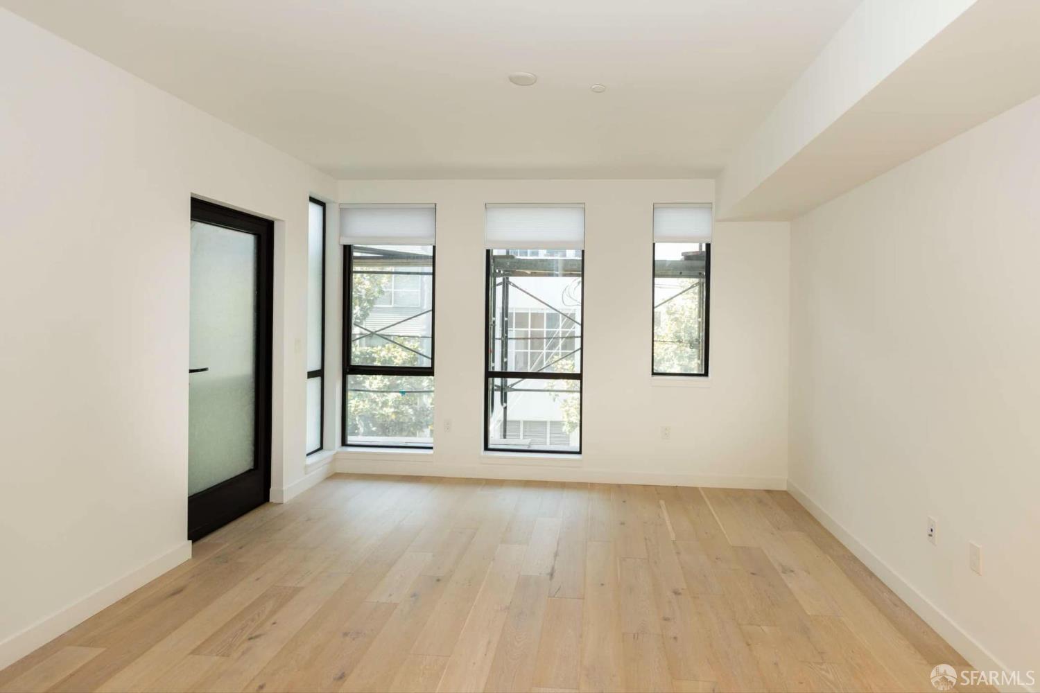 99 Rausch Street, Unit 303 San Francisco, CA 94103 - Photo 7 of 37 an empty room with wooden floor and windows
