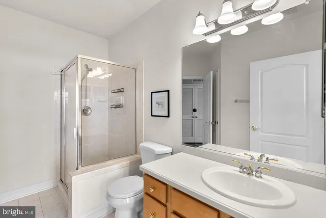 a bathroom with a sink a toilet and shower a mirror