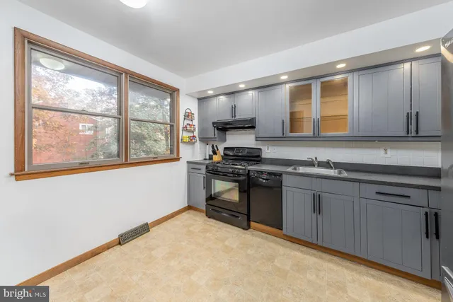 a kitchen with granite countertop a stove a sink and a refrigerator