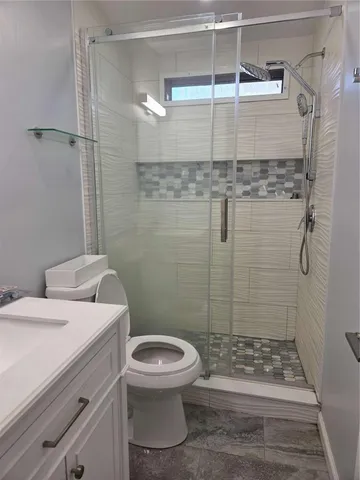 a view of an empty room with wooden floor and a ceiling fan