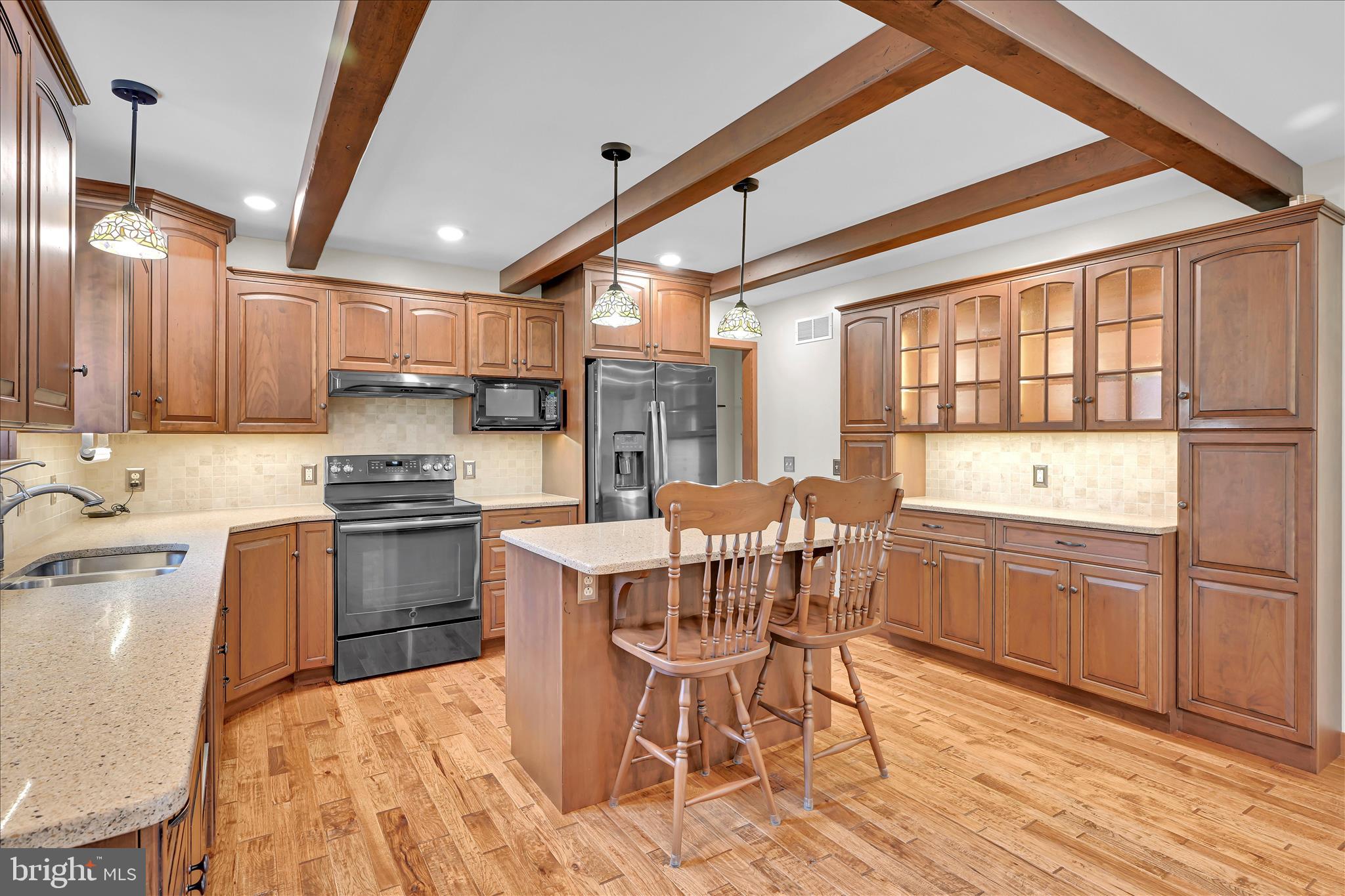 643 Deturksville Road Pine Grove, PA 17963 - Photo 31 of 59 a kitchen with stainless steel appliances granite countertop a stove top oven a sink dishwasher a dining table and chairs with wooden floor