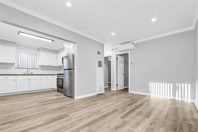 a view of a kitchen with refrigerator and white cabinets