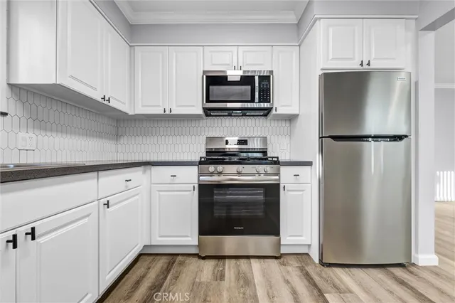 a kitchen with white cabinets and stainless steel appliances