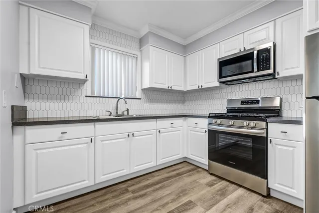 a kitchen with granite countertop white cabinets stainless steel appliances and sink
