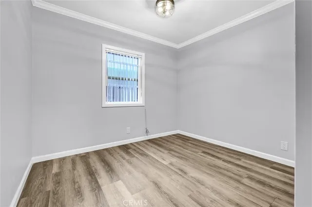 a view of an empty room with window and closet area