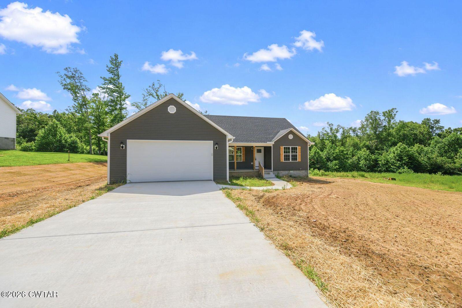 435 Old Huntingdon Road Lexington, TN 38351 - Photo 21 of 26 a front view of a house with a yard and garage