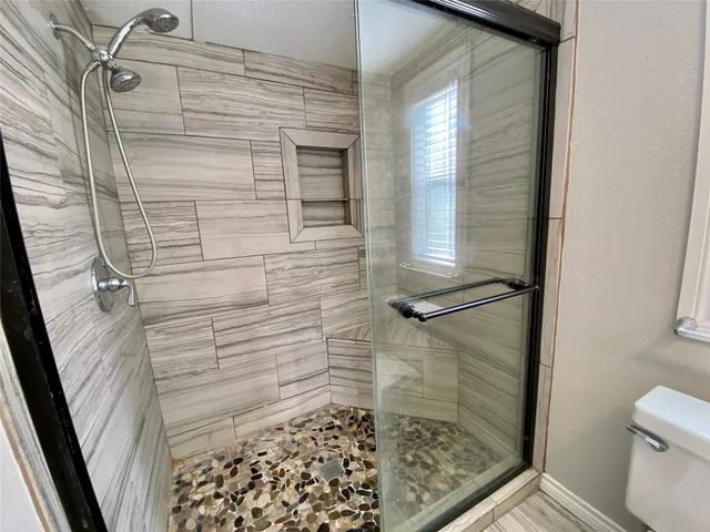 a bathroom with a shower and toilet