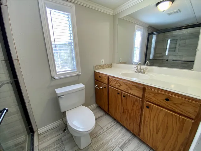 a bathroom with a granite countertop toilet sink and mirror