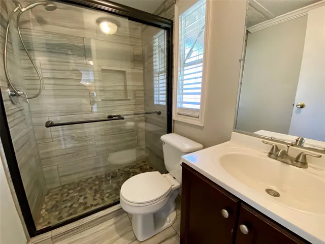 a bathroom with a sink a toilet and shower