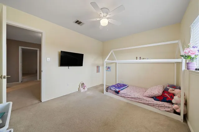 a bedroom with furniture and a chandelier fan