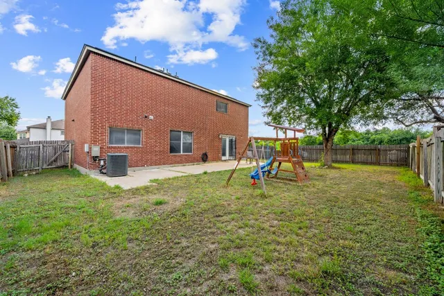 a backyard of a house with table and chairs